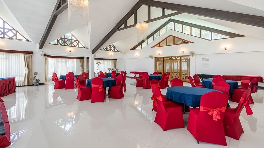 event hall with red chairs and blue table at Summit Lillium Hotel & Spa, Kalimpong