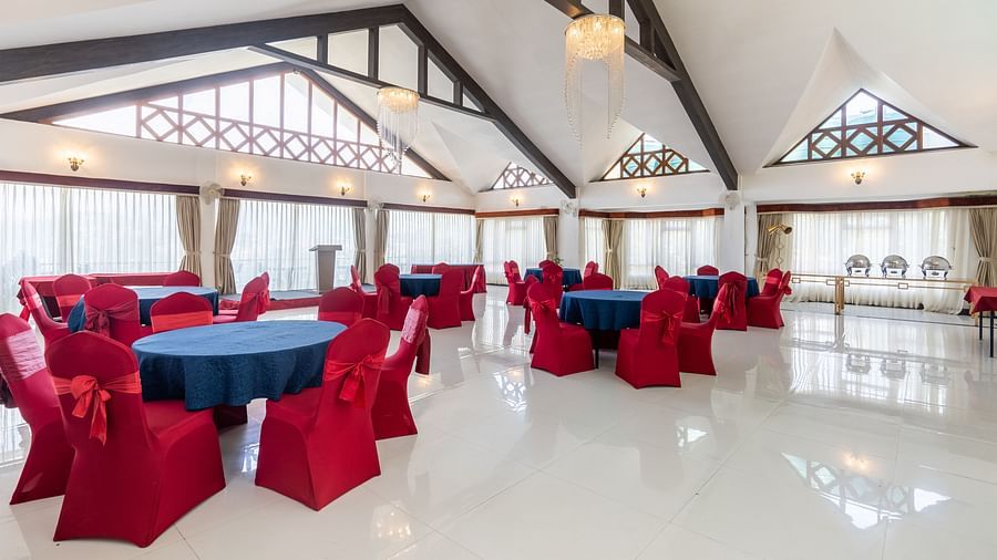 event hall with red chairs and blue table at Summit Lillium Hotel & Spa, Kalimpong