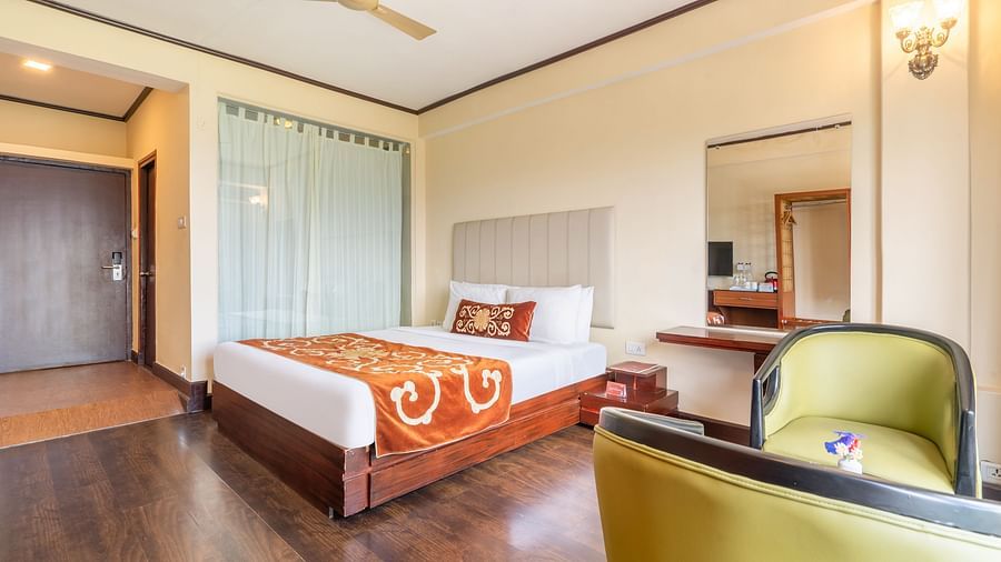 king size bed and chairs of premium room at Summit Lillium Hotel & Spa, Kalimpong