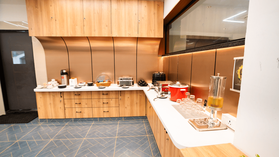 Buffet counter with food trays, plates, and serving utensils arranged neatly at Sunrise Business Hotel, Hyderabad.