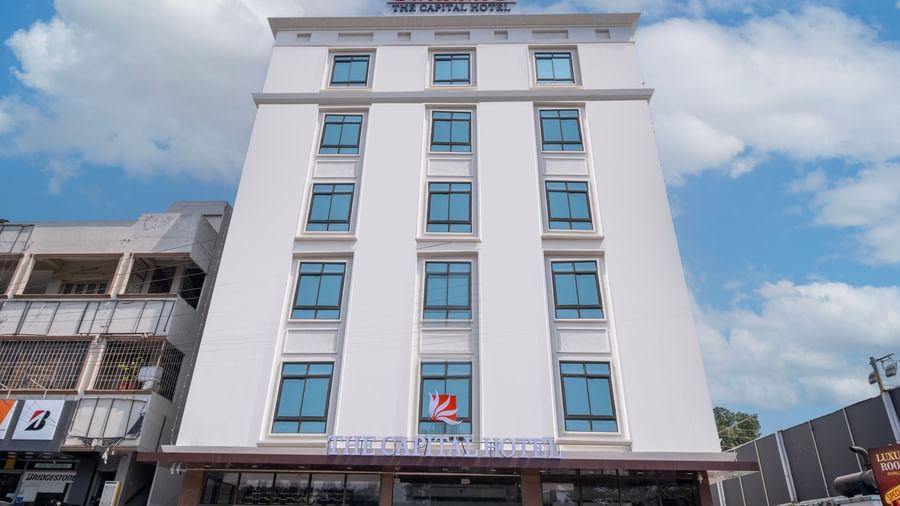 Exterior front view of Swarna's The Capital showcasing its tall modern architecture against blue skies.