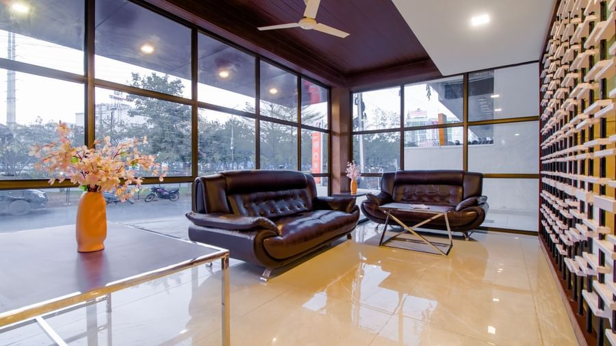 Spacious lounge with leather sofas glass walls natural light and stylish interiors at Swarna's The Capital.