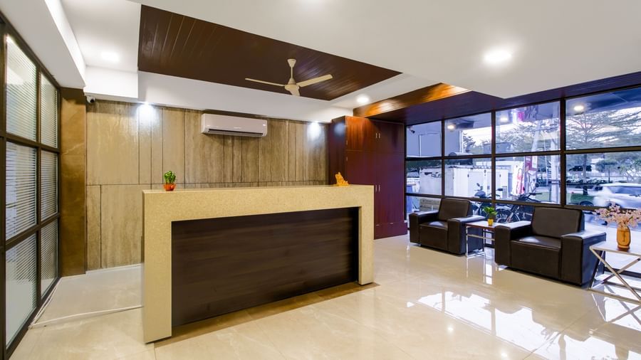 Reception desk with seating area polished flooring and contemporary design at Swarna's The Capital.