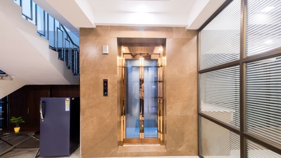 Sleek lift lobby with glass walls polished tiles and elegant modern design at Swarna's The Capital.