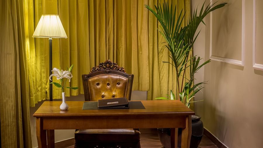 Large table with a stationery set and a vase decorated with flowers.