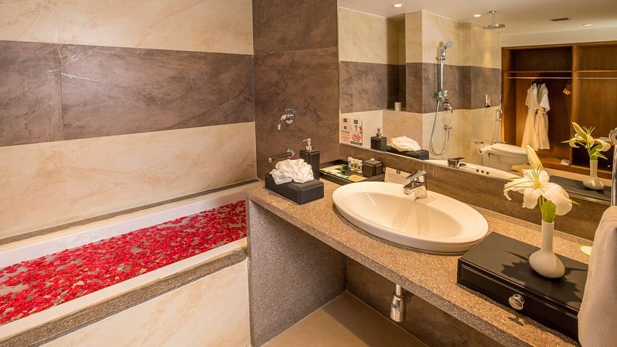 Bathroom with bright lighting and a large mirror set horizontally above the washbasin.