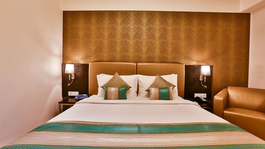 Front view of a room with a double bed and side tables with night lights at T24 Residency, Andheri East, Mumbai