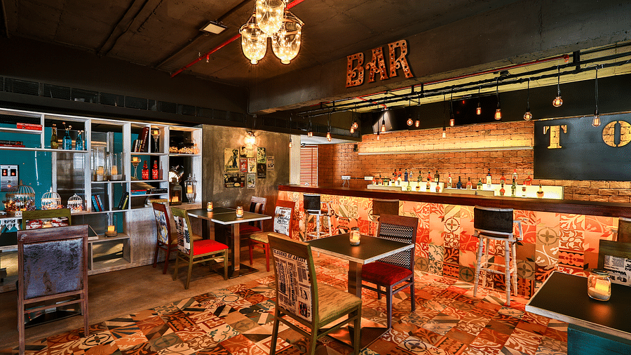 Indoor seating in the restaurant at T24 Residency, Andheri East, Mumbai with a bar counter in the backdrop