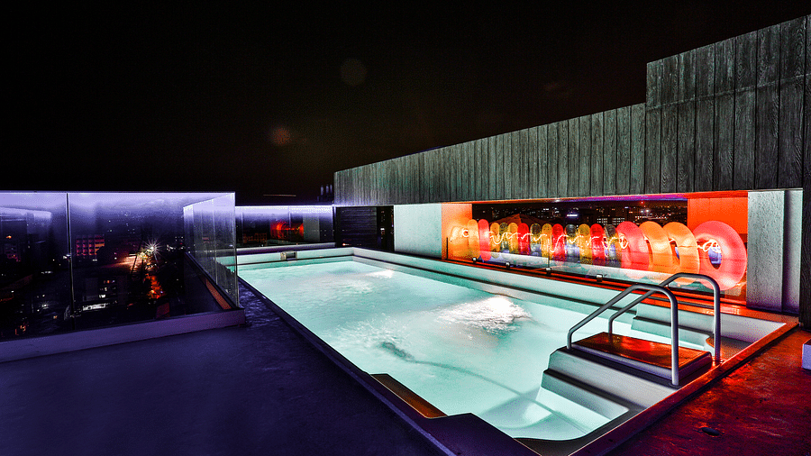 A well-lit rooftop swimming pool at T24 Residency, Andheri East, Mumbai at night