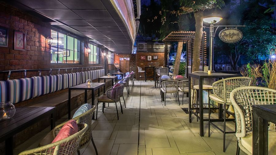 A cosy outdoor seating area with tables and chairs, perfect for enjoying a drink under the stars  | T24 Retro