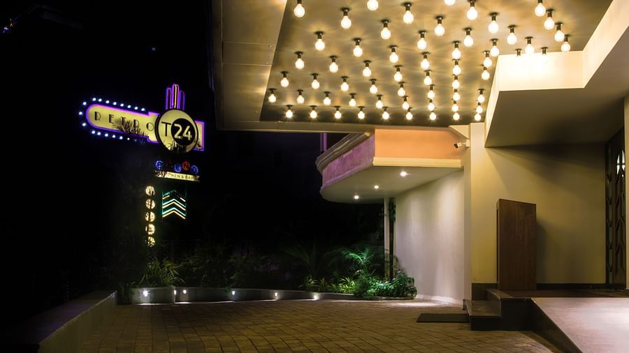 A well-lit entrance to a building with a unique sign and a ceiling full of lights.