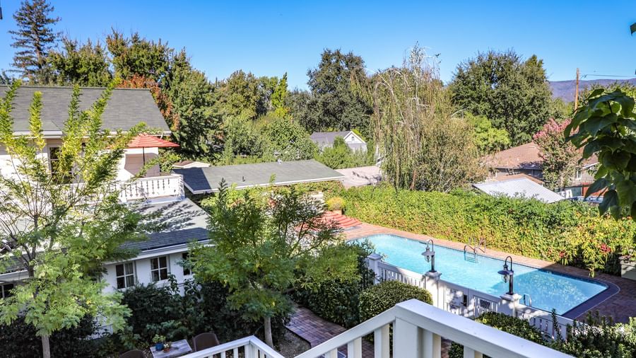 An aerial view of the Tallman Hotel's inviting outdoor swimming pool surrounded by lush greenery and buildings.