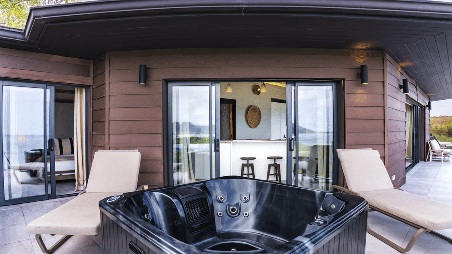 A private terrace with a hot tub, sun loungers, and glass doors opening into the suite at Suite 35, Tamarind Hills Resort and Villas.