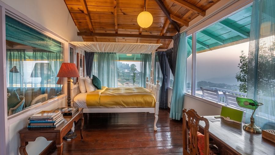 wide angle view of a room with a bed and large windows at Te Aroha By Shervani, Mukteshwar