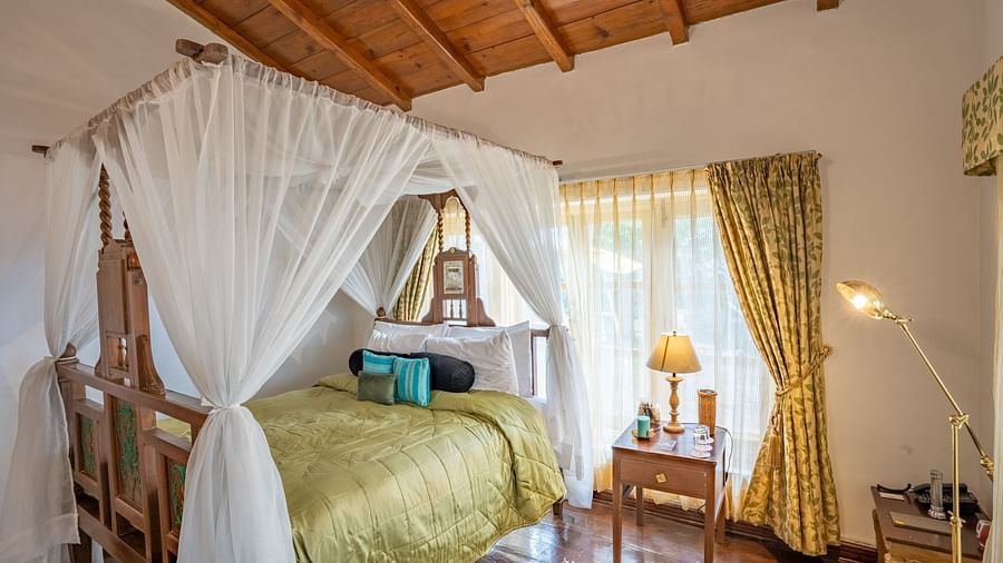 A bed with canopy inside one of the rooms at Te Aroha By Shervani, Mukteshwar