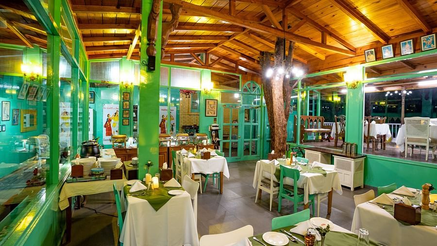 A dining space with chairs, tables and wooden ceiling at Te Aroha By Shervani, Mukteshwar