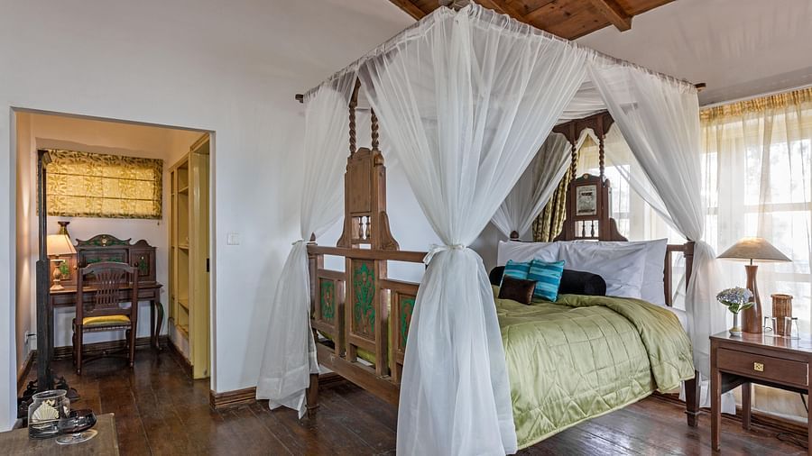 Bed with side canopy and a lamp on the side of the bed at 3 bhk cottage at Te Aroha by Shervani Mukteshwar