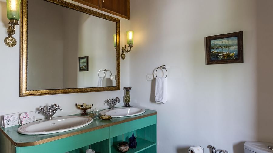 Sink with a toiletries and a rectangle mirror at Te Aroha by Shervani Mukteshwar