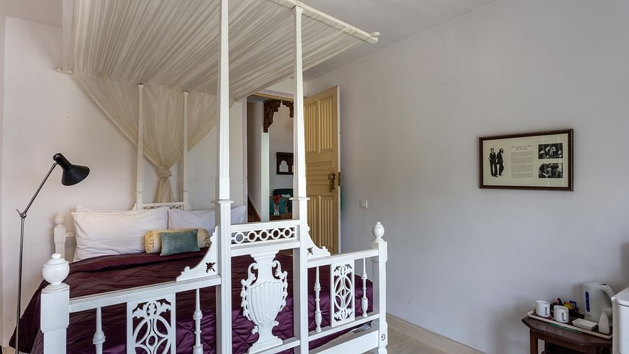 3 bhk cottage with intricately designed bed frame and a fame on the wall at Te Aroha by Shervani Mukteshwar
