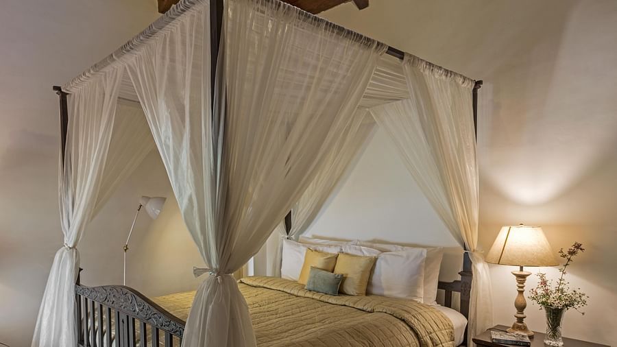 Bed with side canopy and a lamp on the side of the bed at 3 bhk cottage at Te Aroha by Shervani Mukteshwar