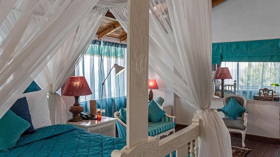 Close up view of a bed with side canopy and lamp on the side of the bed at Bed with side canopy and a lamp on the side of the bed at 3 bhk cottage at Te Aroha by Shervani Mukteshwar