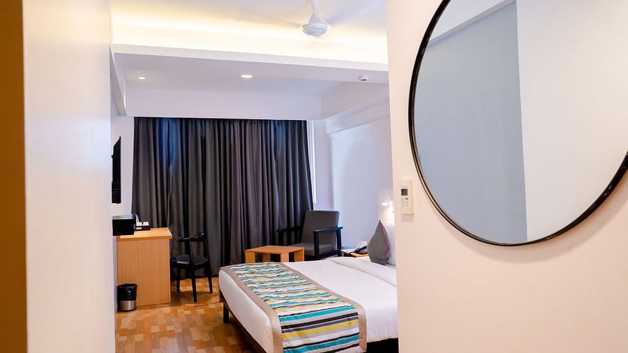 A modern hotel room with a bed, gray curtains and contemporary decor - TGI Ameya Grand, Goa