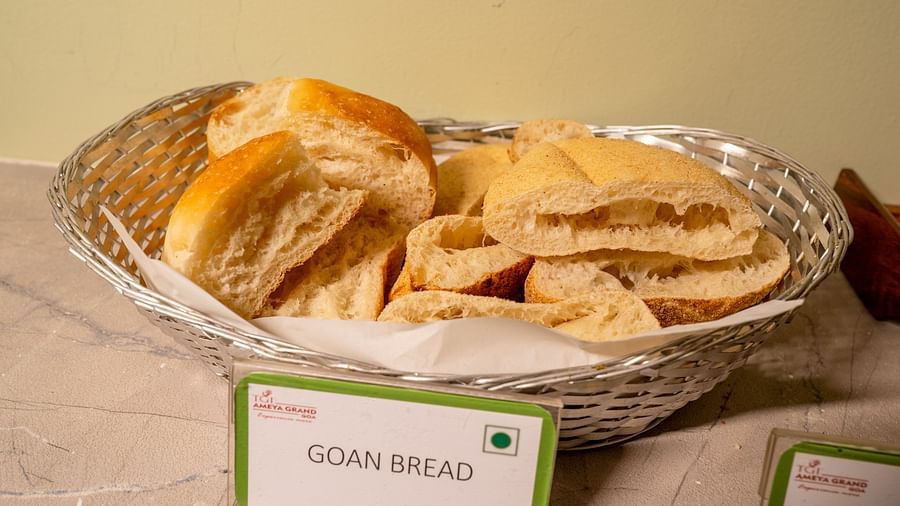 A basket of sliced Goan bread on a buffet table with a label in front - TGI Ameya Grand, Goa