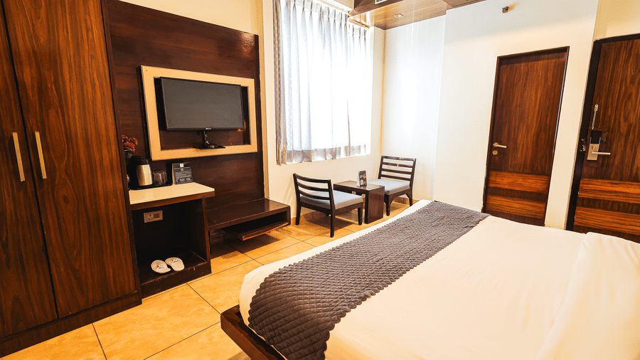 Modern accommodation with wooden accents, work desk and large windows at TGI Apple Inn, Ajmer Road, Jaipur.