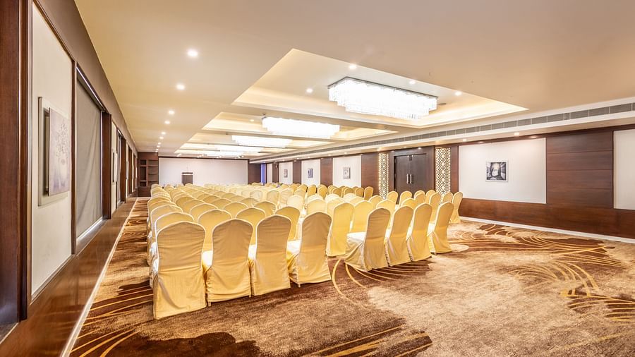 Banquet room with angled view of rows of neatly aligned chairs facing a presentation area