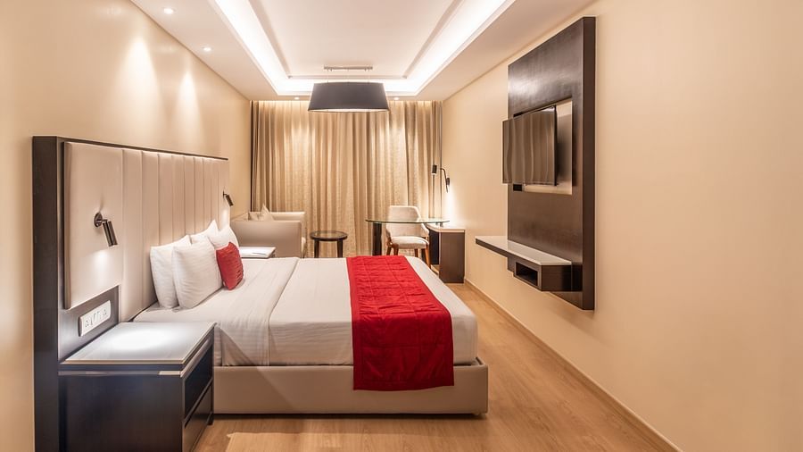 Cozy double room featuring a red runner and a flat-screen TV of Grand Suite- TGI Grand Fortuna, Krishnagiri Main Road, Hosur