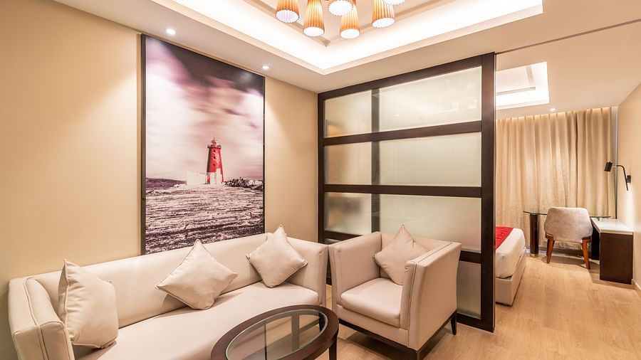 Fortuna suite's cosy lounge area with plush sofas and a round coffee table- TGI Grand Fortuna, Krishnagiri Main Road, Hosur