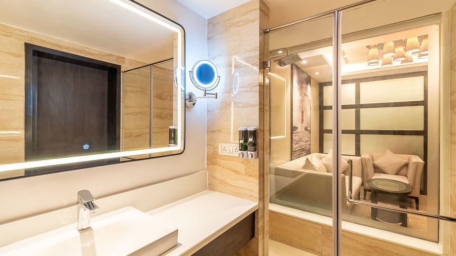Bathroom with a vanity counter, mirror, and glass partition- TGI Grand Fortuna, Krishnagiri Main Road, Hosur