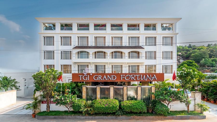Front view of The Grand Victoria hotel with a facade and lush landscaping- TGI Grand Fortuna, Krishnagiri Main Road, Hosur