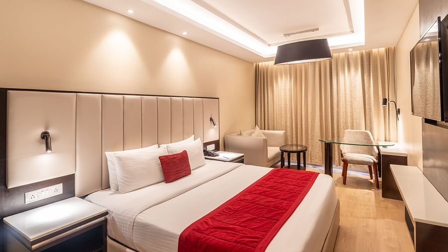 Grand Suite with a huge bed, red accents, and soft ambient lighting,- TGI Grand Fortuna, Krishnagiri Main Road, Hosur