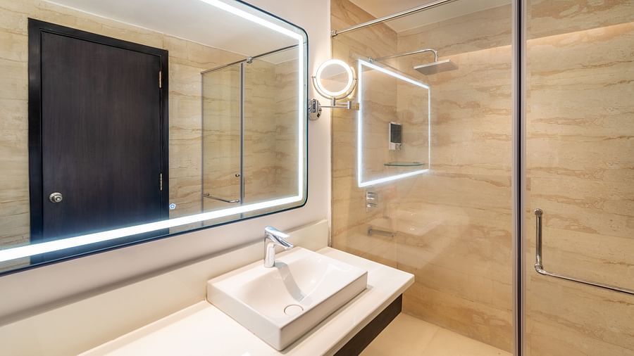 Modern bathroom with a sleek vanity and illuminated mirror. Grand Suite- TGI Grand Fortuna, Krishnagiri Main Road, Hosur