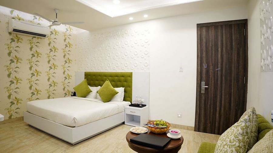 Another view of a chic bedroom with a patterned feature wall, modern decor and a green velvet headboard - TGI Insignia, Bhopal