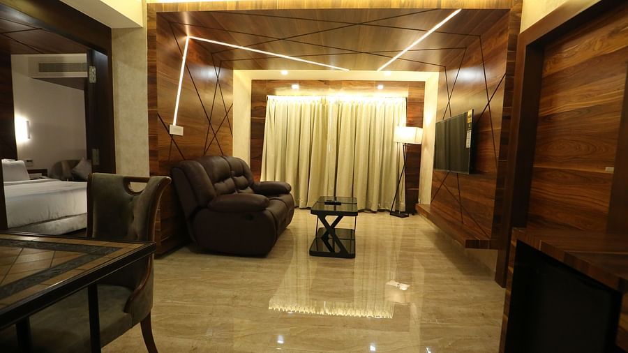 Premium Suite with a seating area, a television, and a view of the hallway - TGI SPS Grand, Coimbatore
