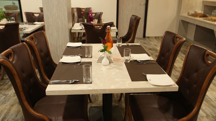 A dining area with set tables surrounded by chairs - TGI SPS Grand, Coimbatore