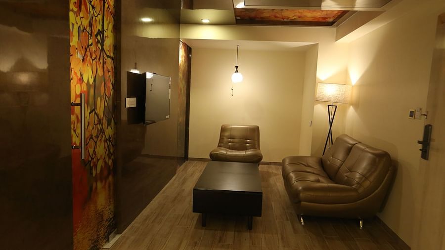 A seating area of Club Suite with sofas around a coffee table - TGI SPS Grand, Ram Nagar, Coimbatore