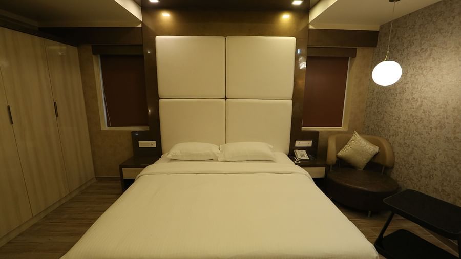A close up view of a king size bed under ambient lighting at Club Suite - TGI SPS Grand, Ram Nagar, Coimbatore