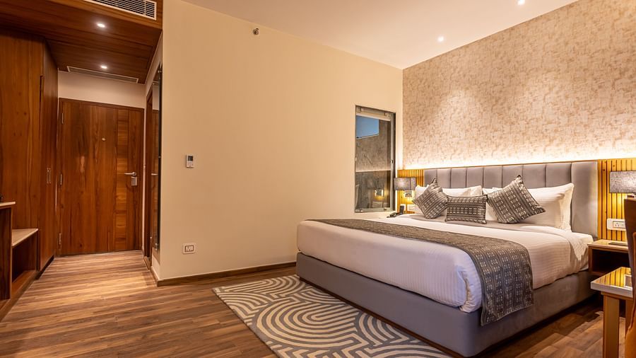 An image of a Family Room with a bed, bed side table, lamps, and rug - The Belvedere Himalayan Retreat, McLeodganj