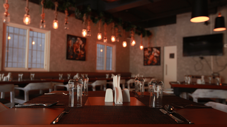 A perspective view of the restaurant's seating area with framed artwork on the walls and warm ambient lighting at The Bull Boutique Hotel.
