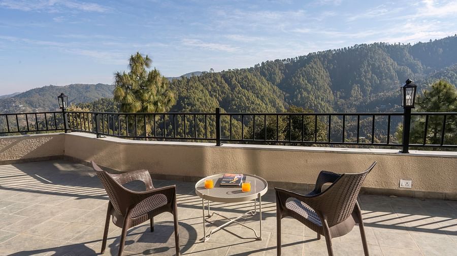 A spacious balcony at The Chamomile Estate, furnished with outdoor seating and offering serene mountain views.