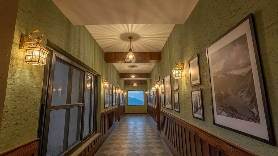 An elegantly styled hotel corridor at The Chamomile Estate, adorned with wall paintings and bathed in warm lighting.