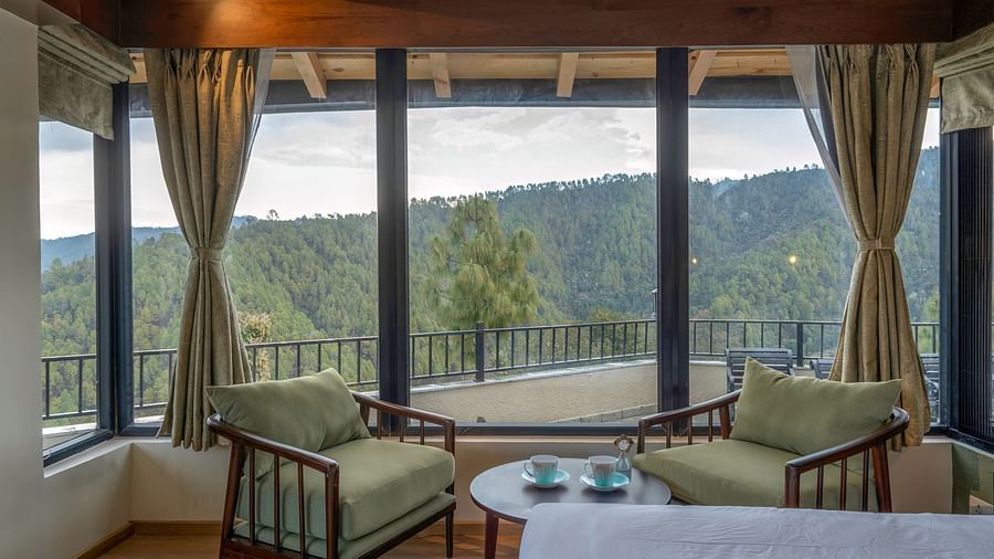 Spacious room with a seating area featuring armchairs and a view through large windows at The Chamomile Estate.