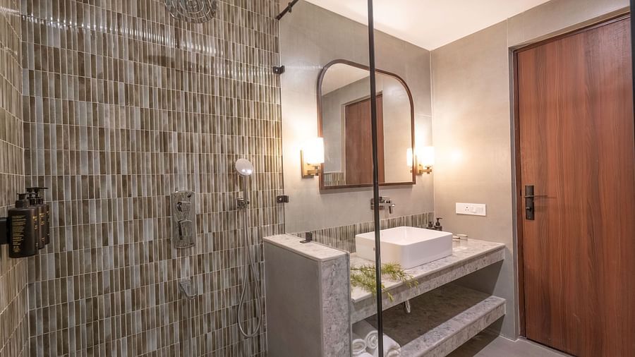 Bathroom with a modern shower and sink, with a wall-mounted mirror above it at The Chamomile Estate.