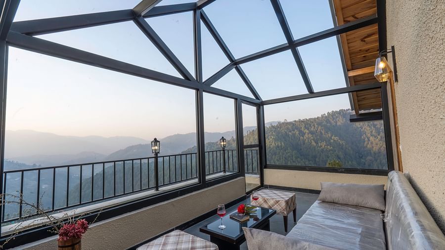 Glass-enclosed balcony with seating offering panoramic views at The Chamomile Estate.