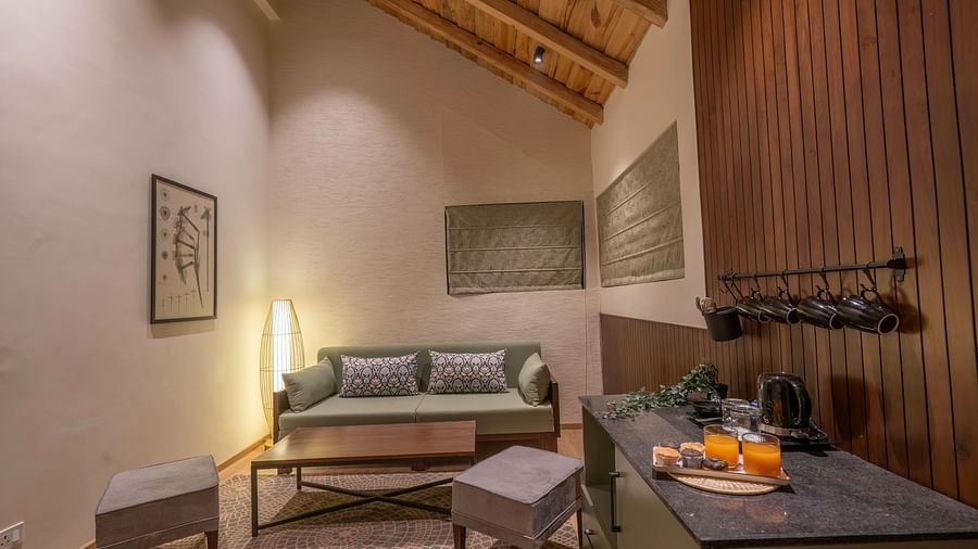 Living area with a sofa, table, and wall-mounted photographs at The Chamomile Estate.