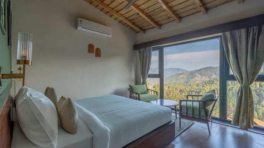 View from beside the headboard, with a spacious room and a view of the mountains at The Chamomile Estate.