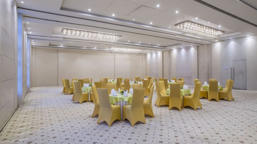 A meeting room with cluster seating arrangements of yellow chairs at The Citi Residenci Hotel, Asansol.